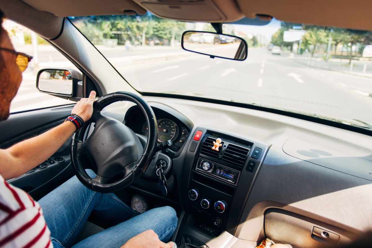 momak vozi automobil po gradu